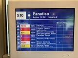 パラディーゾ（Paradiso）駅到着直前の列車内表示器。同駅で接続する列車とバスがすべて表示される。2番バスは3分遅れの表示が出ている（筆者撮影）