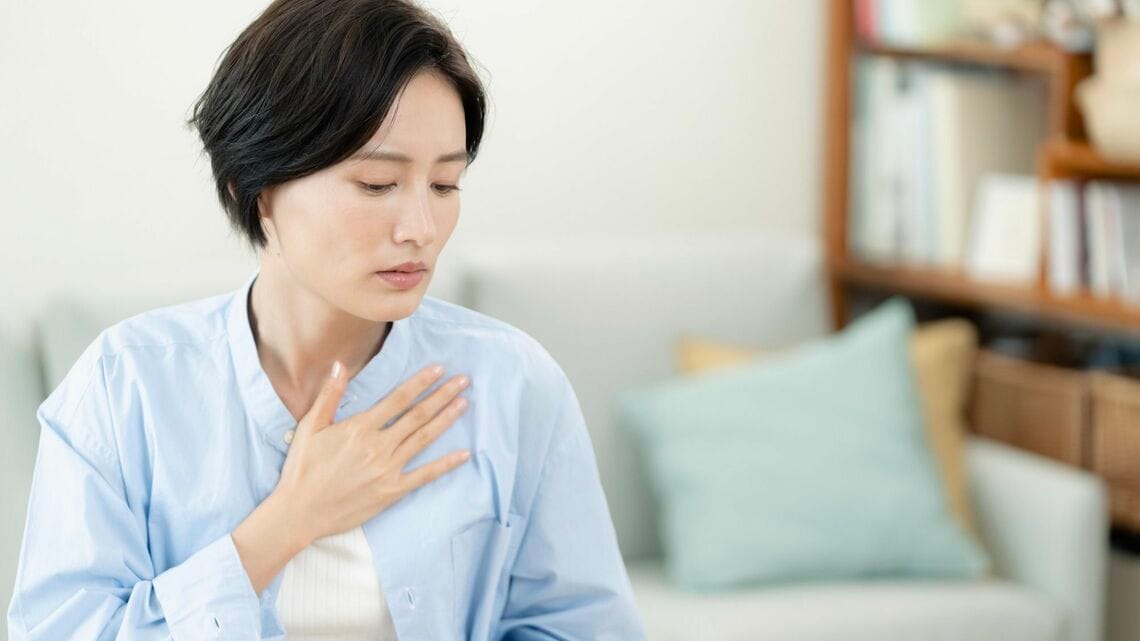 胸に手を当てる女性