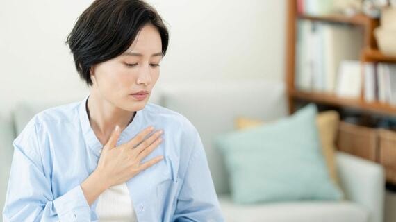 胸に手を当てる女性