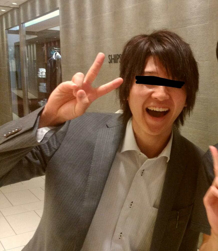 笑顔で写真に写るスーツ姿の著者