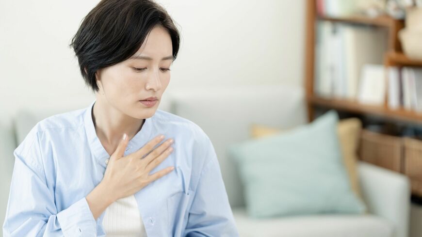 胸に手を当てる女性