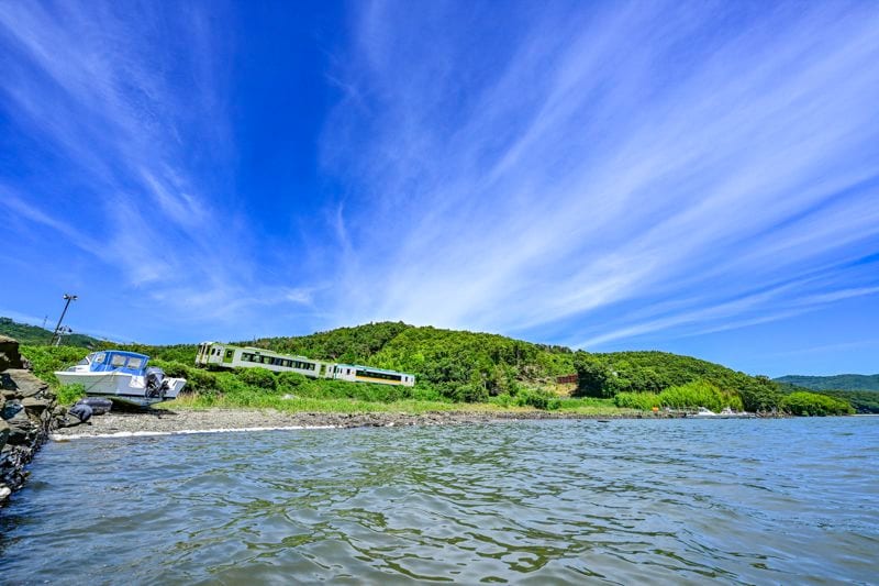 養殖が盛んに行われている万石浦（まんごくうら）をゆく石巻線。万石浦は種牡蠣の養殖が盛んで世界に輸出されており、世界中の牡蠣の8割はここ万石浦の海にルーツがあるとも言われている（筆者撮影）