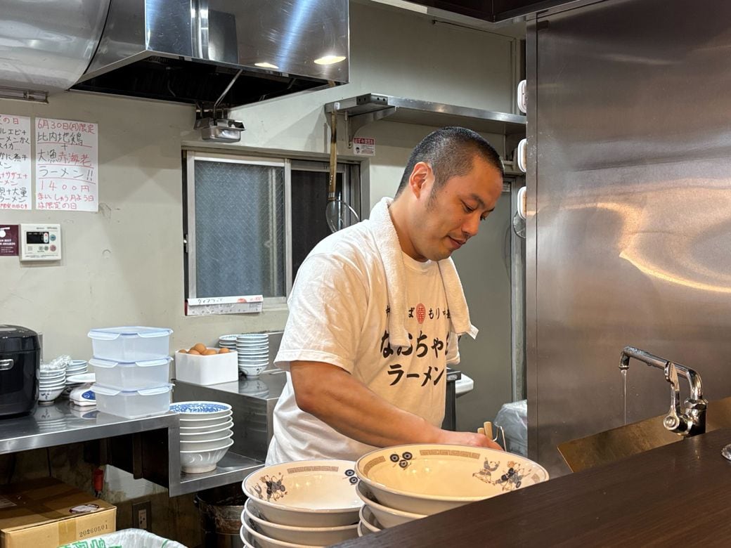 調理中の栄市さん（筆者撮影）