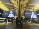 カナリーワーフ駅に掲げられた巨大な女王の肖像（写真：後藤卓也）