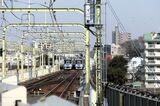複々線の多摩川橋梁を渡って登戸駅へ向かってくる快速急行（左）と各駅停車（記者撮影）