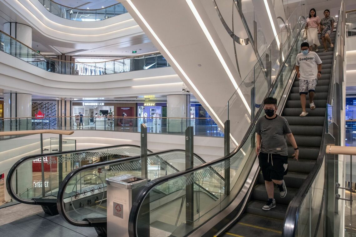 止まったエスカレーターを歩いて降りる人々（武漢のショッピングモール､8月22日）Source: Bloomberg