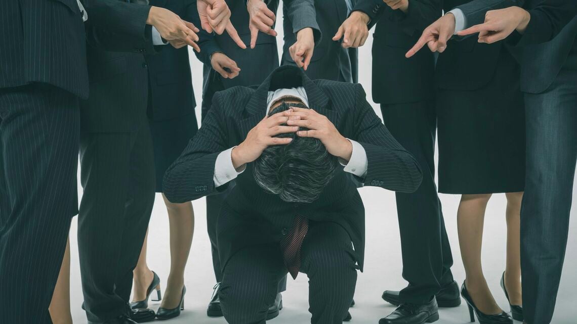 若手に囲まれるベテラン会社員