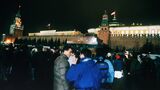 ゴルバチョフ大統領辞任を受け、降ろされたソ連国旗の代わりにロシア国旗が掲げられるのを見物する市民（ソ連・モスクワ）（写真：AFP＝時事）
