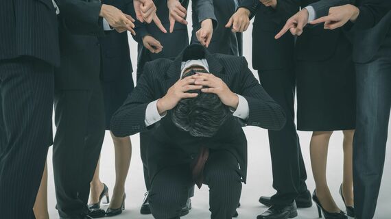 若手に囲まれるベテラン会社員