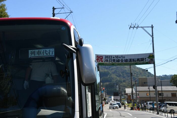 列車代行という表示。その向こうには「全線再開」を