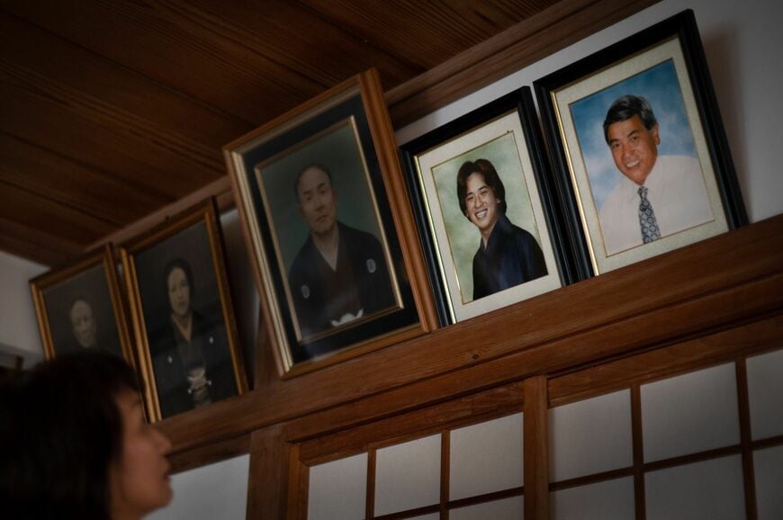 鴨居からほほ笑む（右から）夫・啓治さんと息子・隆陸さんの写真（写真：穐吉洋子）