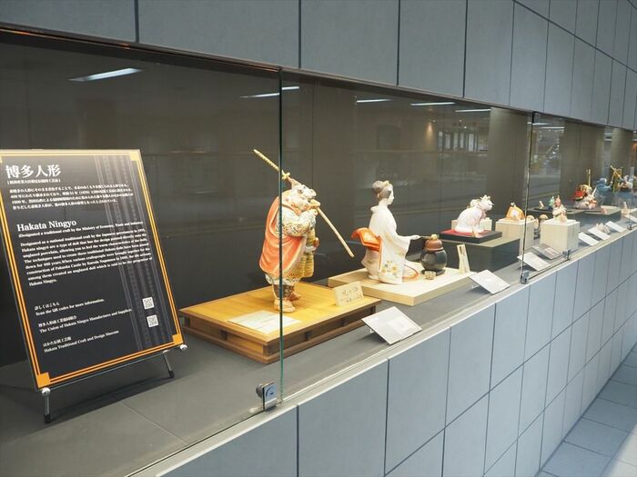 通路壁面に展示された博多人形などの伝統工芸品