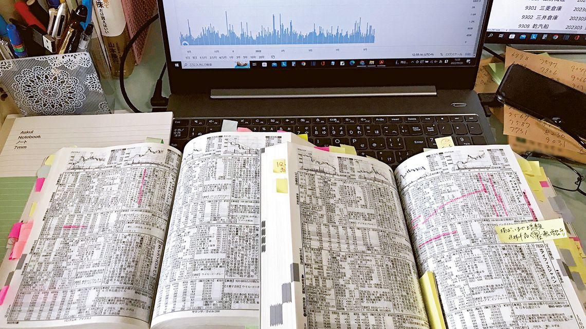机の上で広げた2冊の会社四季報とパソコン