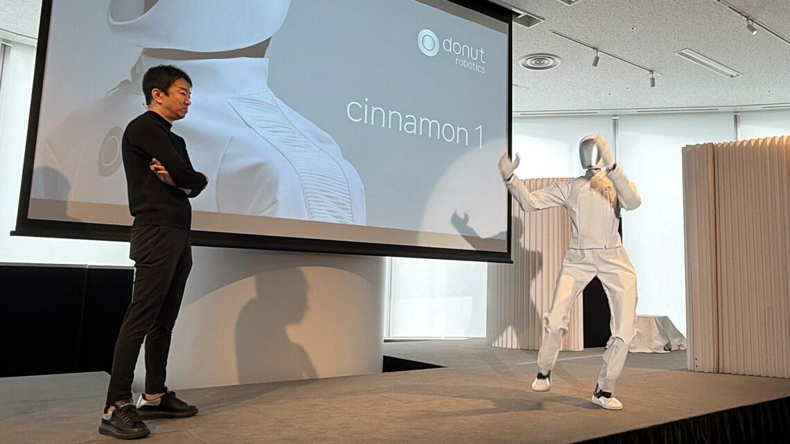 音楽に合わせて踊るcinnamon 1を見守る小野泰助CEO