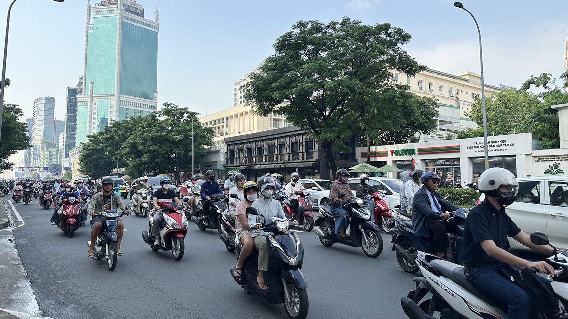 多くのバイクが走行する朝の道路の様子