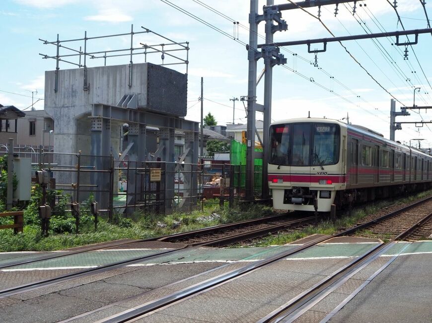 明大前駅付近で建設中の高架橋と京王線の下り電車（記者撮影）