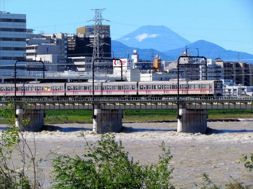 台風一過の快晴、富士山をバックに増水した多摩川を渡る7000系＝2019年10月（撮影：南正時）