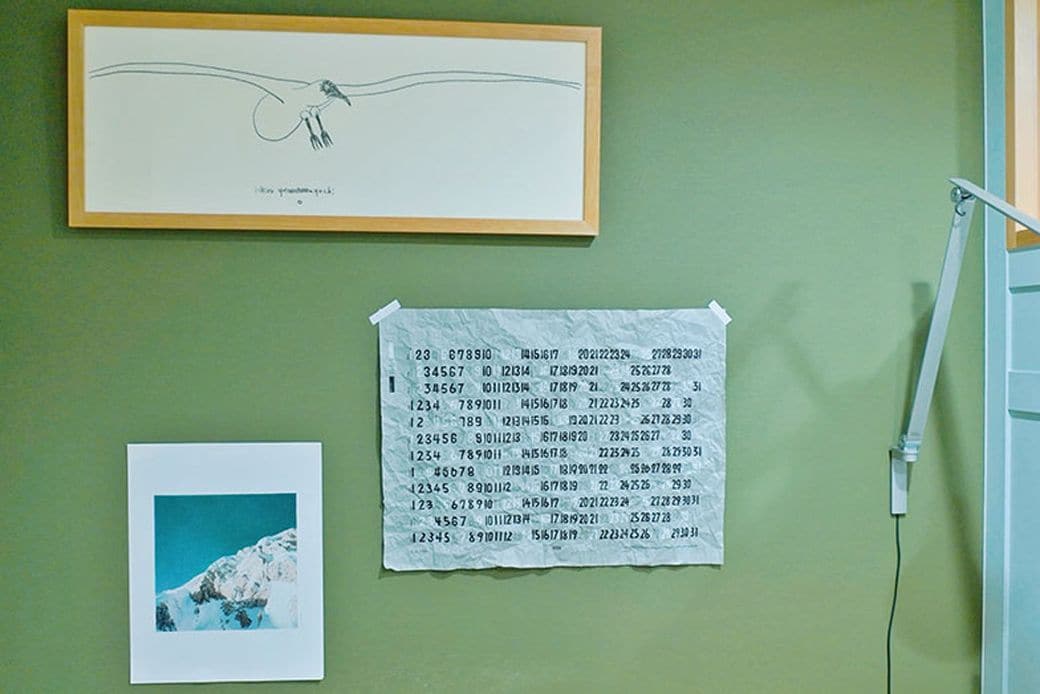 グリーンのアクセントクロスに、飾られたポスターや絵が映える（写真撮影／福永尚史）