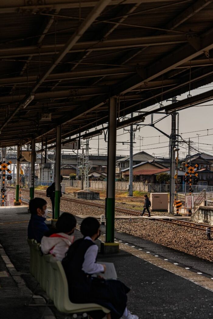 木崎駅で電車を待つ地元の学生と、構内踏切を
