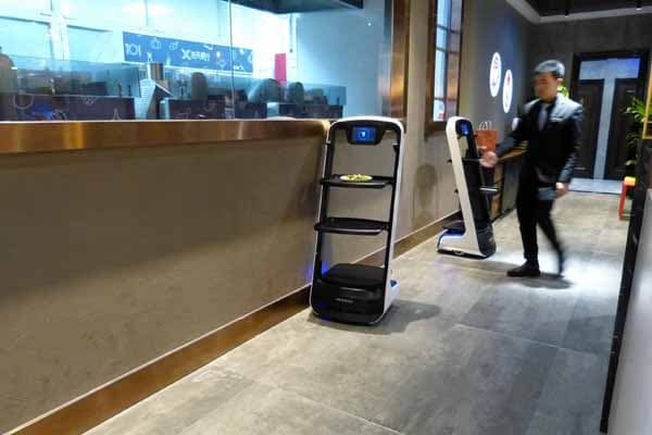 料理ができるとスタッフが配膳ロボットに載せる（記者撮影）
