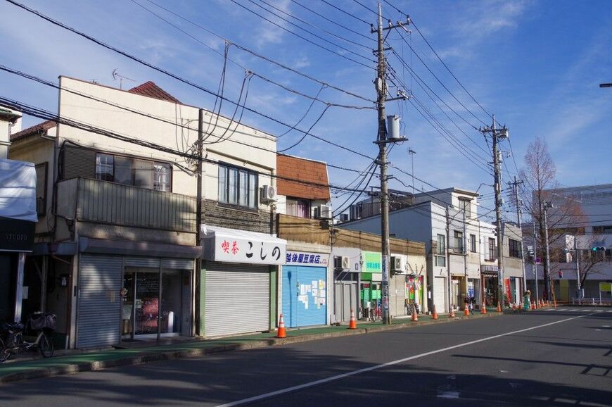 団地北側の商店街。以前はアーケードもあったが、撤去されている。画像奥の交差点近くに「ことぶき食品」が立地していた（筆者撮影）