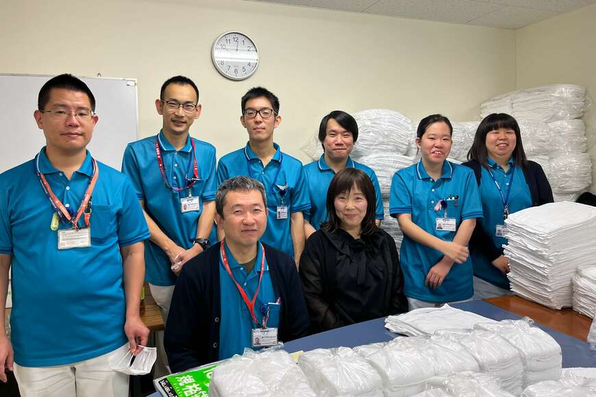 病院で働く係員と岡山さん（写真中央手前で黒い服を着ている女性）（写真：MBTジョブレオーネの岡山さん提供）