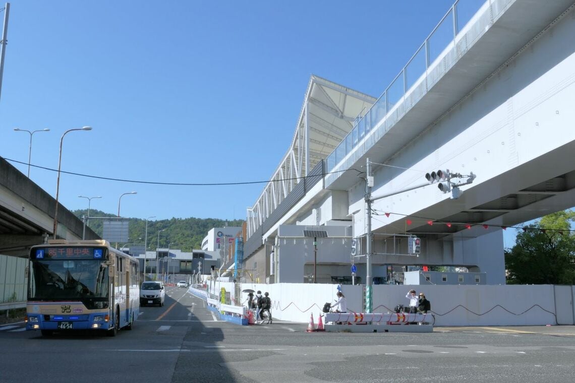 国道171号の萱野交差点の先、高架の上に箕面萱野駅（記者撮影）