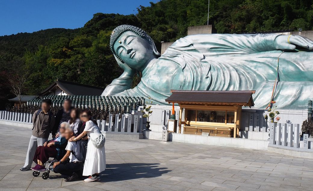 涅槃像前で写真を撮るタイからのグループ観光客