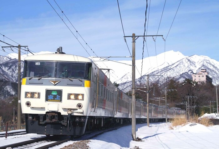 雪景色の谷川岳をバックに走る「水上」