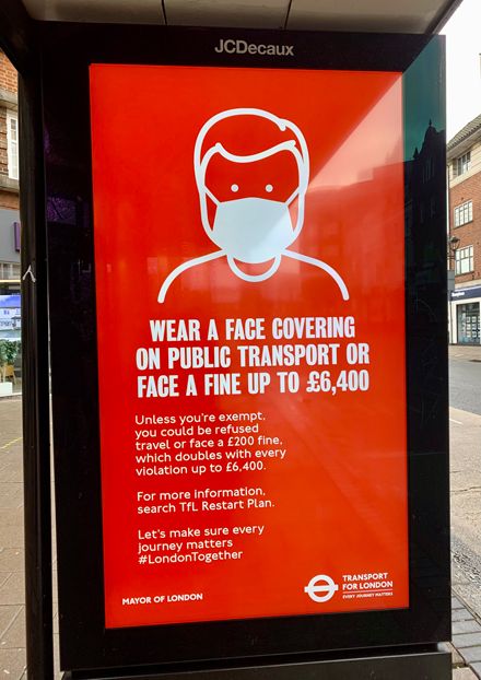 ロンドン市内のバス停に置かれている、マスク着用を奨励する電子サイネージ。着用しない場合は罰金が科されるという（撮影筆者）