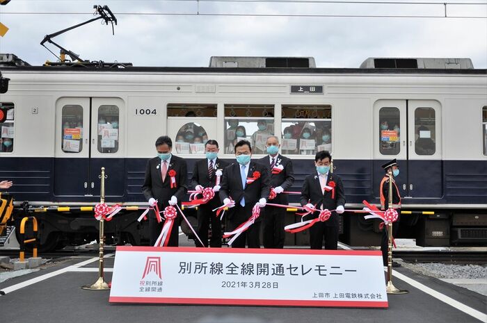 記念列車が停車する前でテープカットする