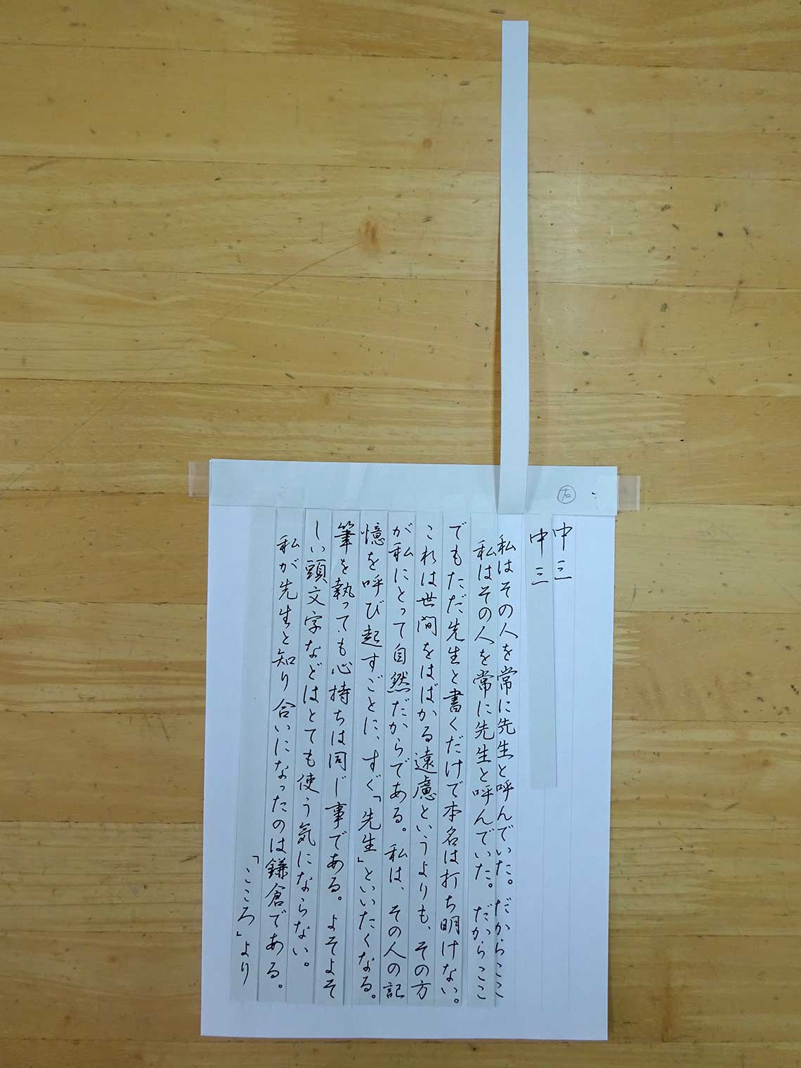 硬筆の教材。行線だけ書かれた紙に、1行ごとに切れ目の入ったお手本を貼った。1行ずつお手本を見ながら書写できるので、刺激が少なく書きやすいという