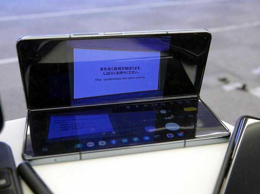 開閉の途中で止められるヒンジを備えた端末が増えている。写真のように、置いたまま撮影できて便利だ。写真は筆者が記者会見で「Galaxy Z Fold4」を使っているときの様子（筆者撮影）