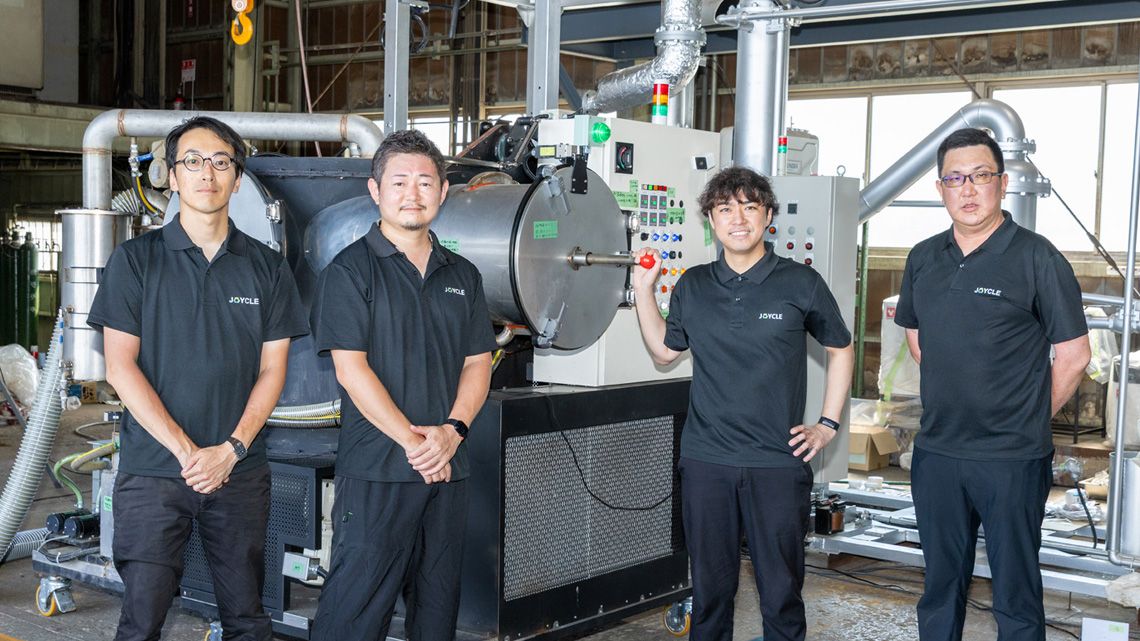 ゴミ資源化装置を前に並ぶ社員たち