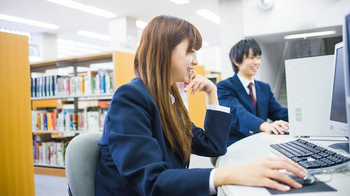 図書室のパソコンを使う高校生
