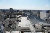 新館屋上から見た東武宇都宮百貨店の屋根。画面中央の線路沿いに百貨店の駐車場がある（記者撮影）