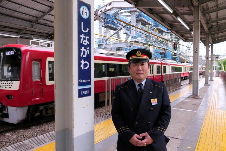 京急品川駅の山室佳久駅長。北品川駅と新馬場駅も管轄する。背後に見えるのは……（記者撮影）