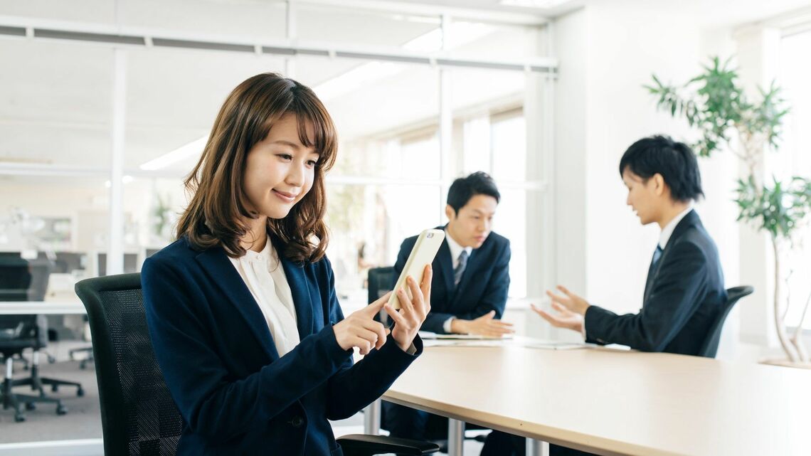 会議中にスマホを見る女性