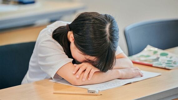 勉強中に机に突っ伏して寝る女の子