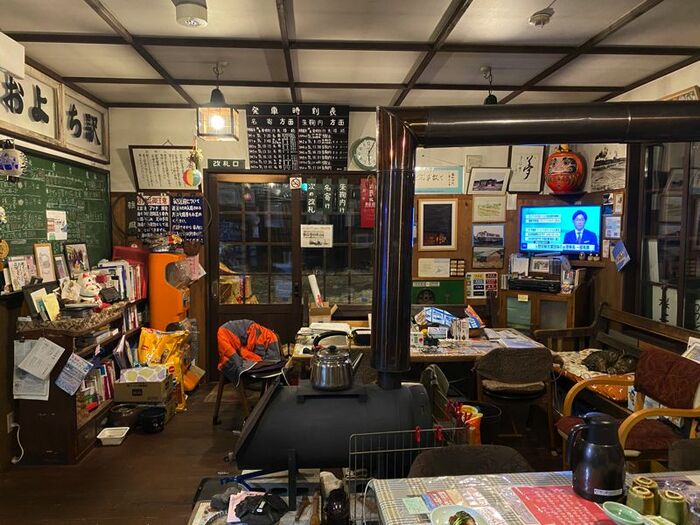 真ん中にストーブが置かれた、待合室のようなリビングダイ