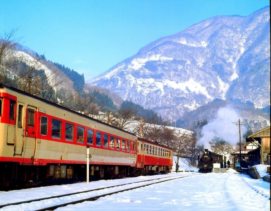 雪晴れの湯野上駅（現・湯野上温泉駅）で交換する気動車とC11形の貨物列車（撮影：南正時）