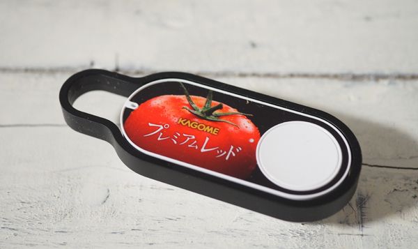 トマトジュース用アマゾンダッシュボタン。黒いフレームは脱着できる。背面に粘着テープがついていて、張り付けられる（著者撮影）