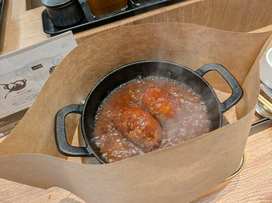 ぐつぐつと煮え、メンチカツの衣にソースが染みていく（筆者撮影）