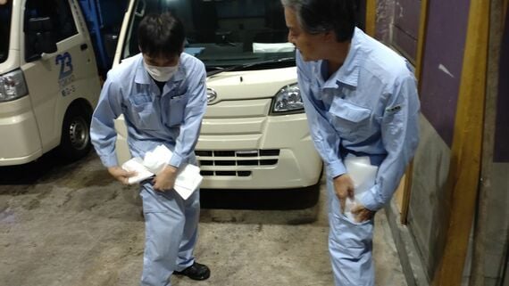 ビニール袋を作業着にしまう様子