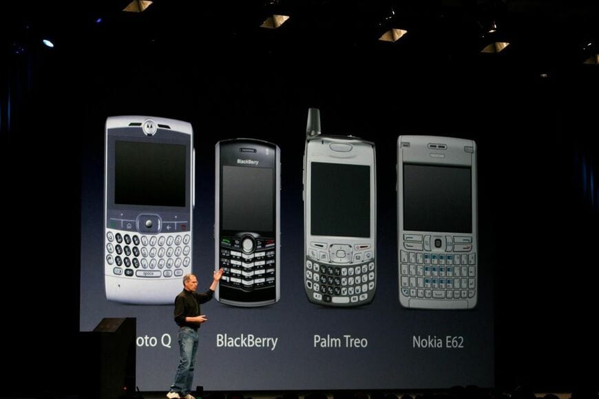 2007年1月のiPhone発表の模様。この時点で既にいくつものスマートフォンがあり、iPhoneは後出し製品だった。スティーブ・ジョブズはそれらが物理的なキーボードを搭載していることが問題だと指摘し、iPhoneでは全面タッチスクリーンを採用した（筆者撮影）