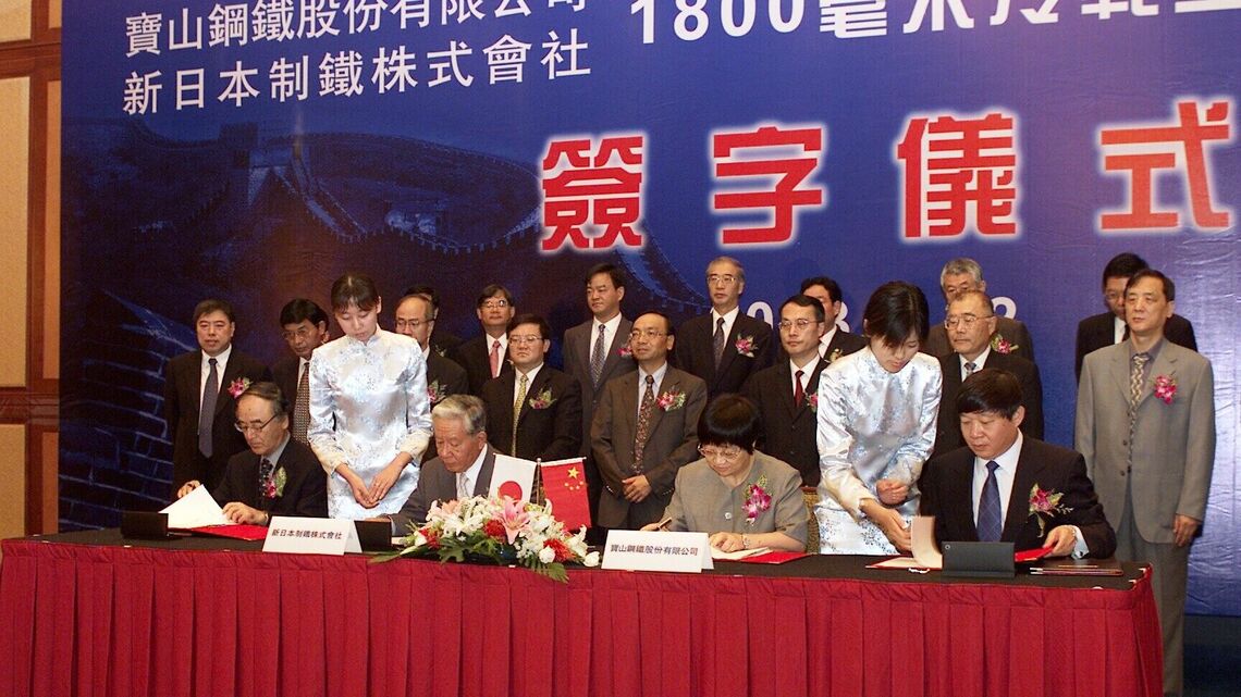 2003年7月に新日本製鐵は宝山鋼鉄と自動車用鋼板を製造・販売する合弁会社設立で基本合意を締結した。左から三村明夫社長と千速晃会長（いずれも当時）。同年の12月にはアルセロールも交えて合弁契約を締結した（写真：時事）