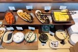 ジョナサンの朝食バイキング。和食のおかずとごはんの友。左上からキムチ、レンコンのきんぴら、茄子の煮びたし、だし巻き玉子、焼のり、温泉卵、漬物、納豆、彩りひじき、とろろ（筆者撮影）