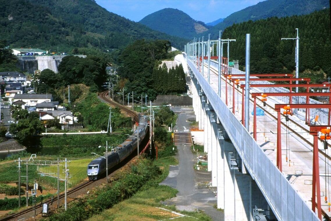 建設中の九州新幹線と在来線特急「つばめ」（左）