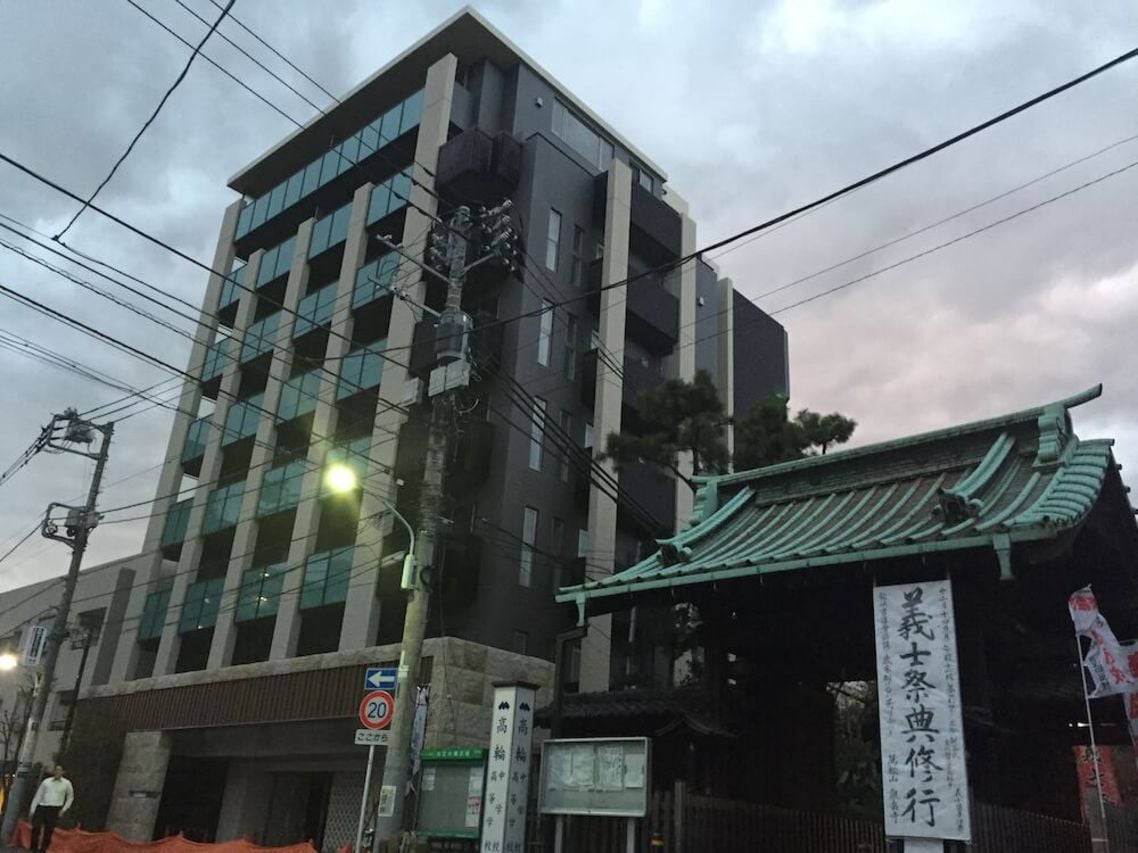 泉岳寺の門の隣には8階建てマンションが