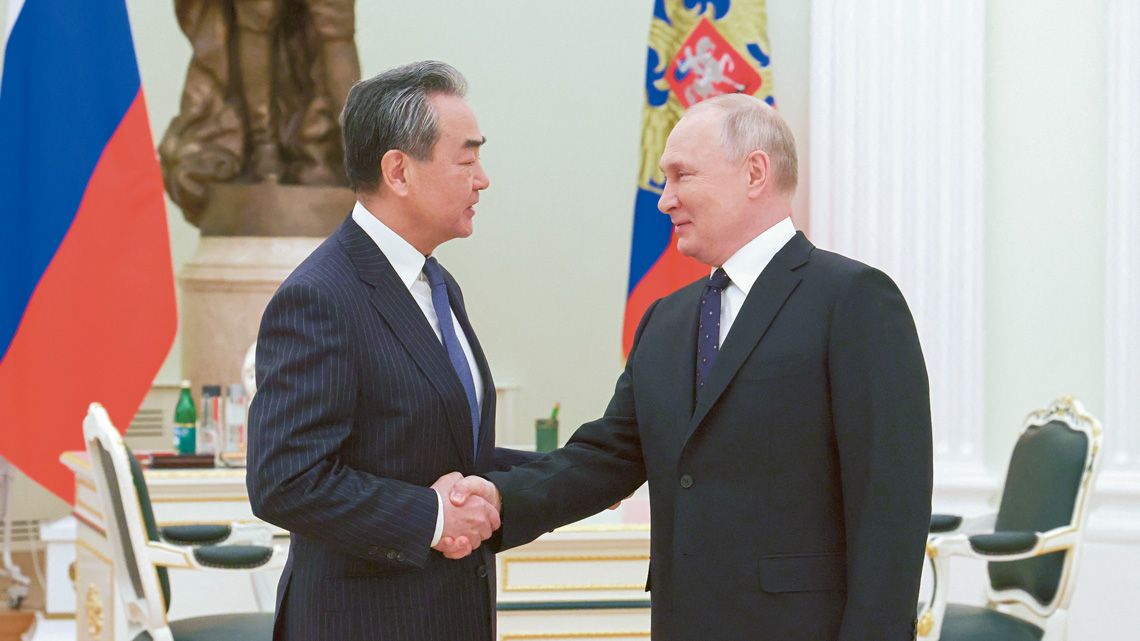 握手を交わすプーチン大統領と王毅・中央政治局員